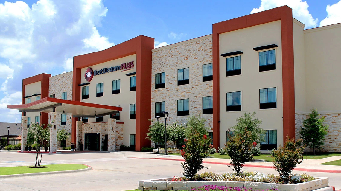 Best Western hotel front of hotel with covered entrance, parking lot, sunny day