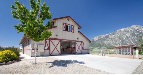Exterior of a white barn with red trim used as a vacation rental in gardnerville Nevada