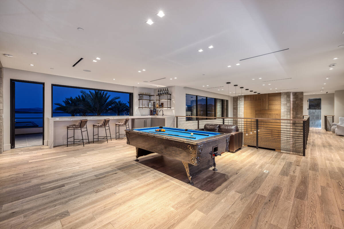 The home features a private upper-level game room with hardwood and marble flooring and fine ar ...