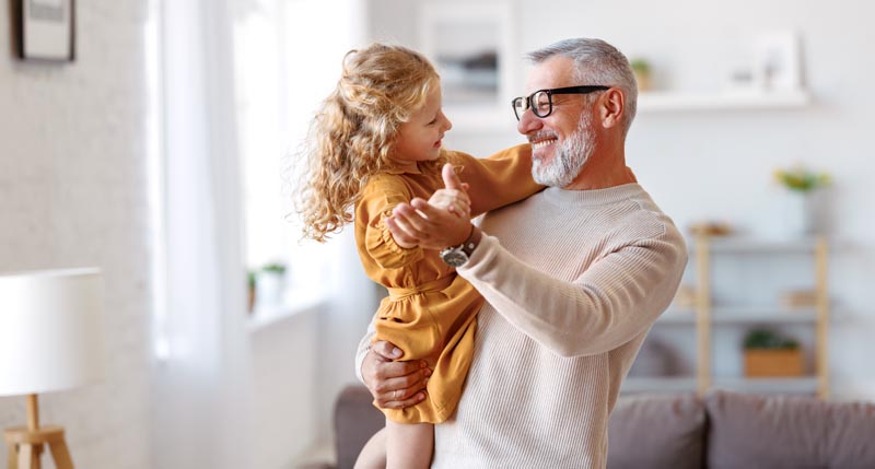 AARP Rewards A man dancing with a toddler smiling and looking at each other