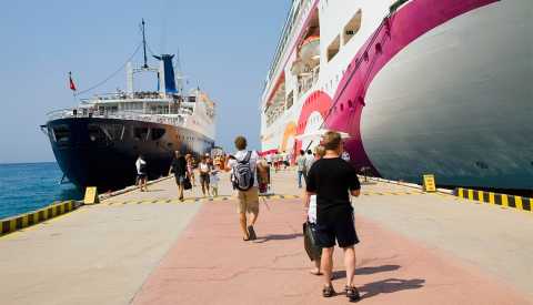 passengers boarding and leaving docked cruise ship