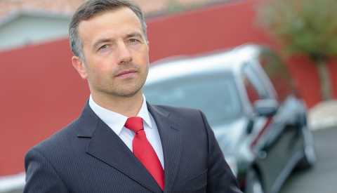 Hombre usando un traje de corbata frente a un carro funerario - Empleos con un salario anual superior a los 100 mil dólares