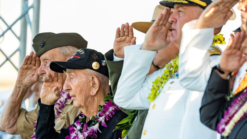 World War II veterans and government officials salute during the 84th Pearl Harbor Remembrance...