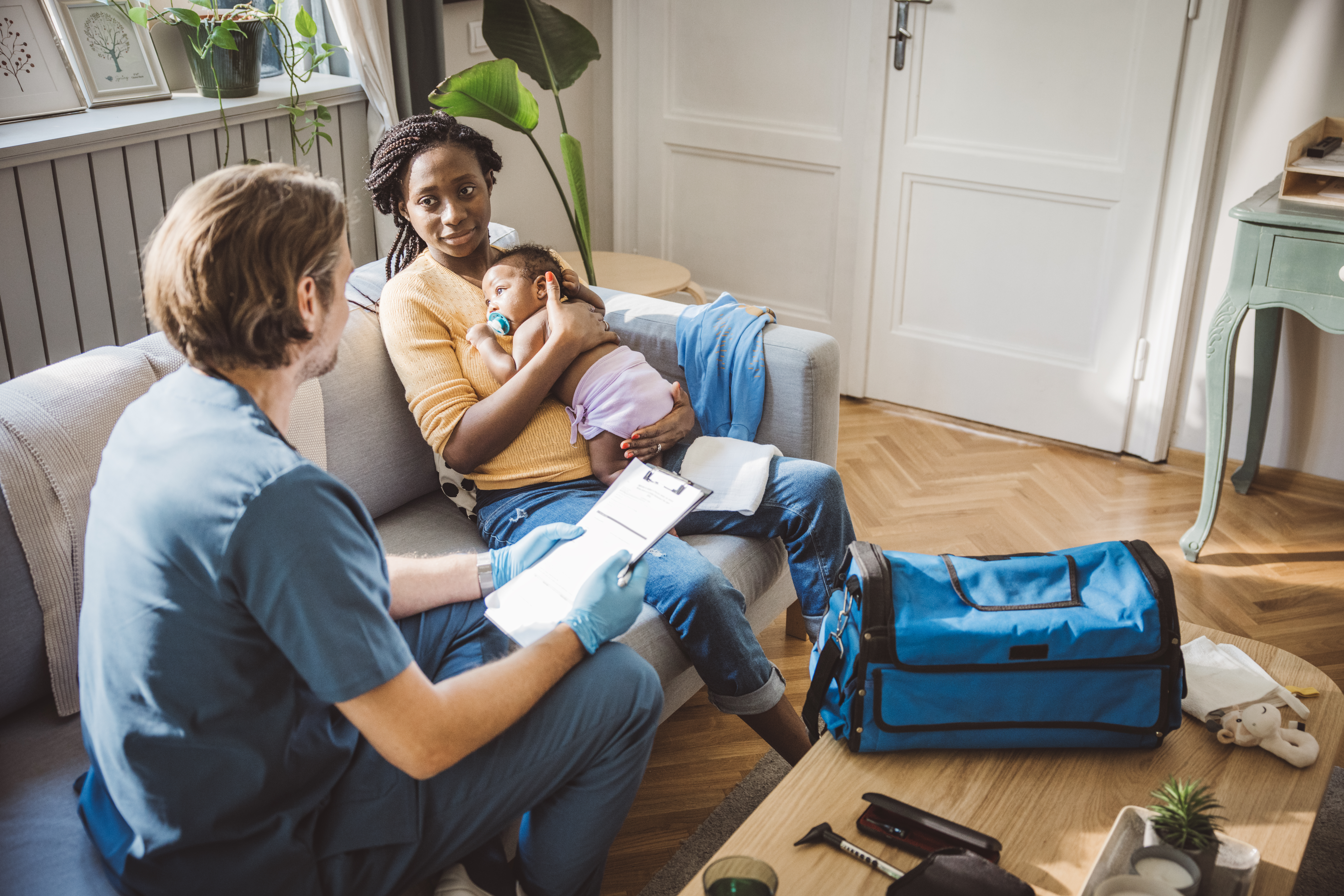 HCBS Woman And Infant Sitting With Doctor