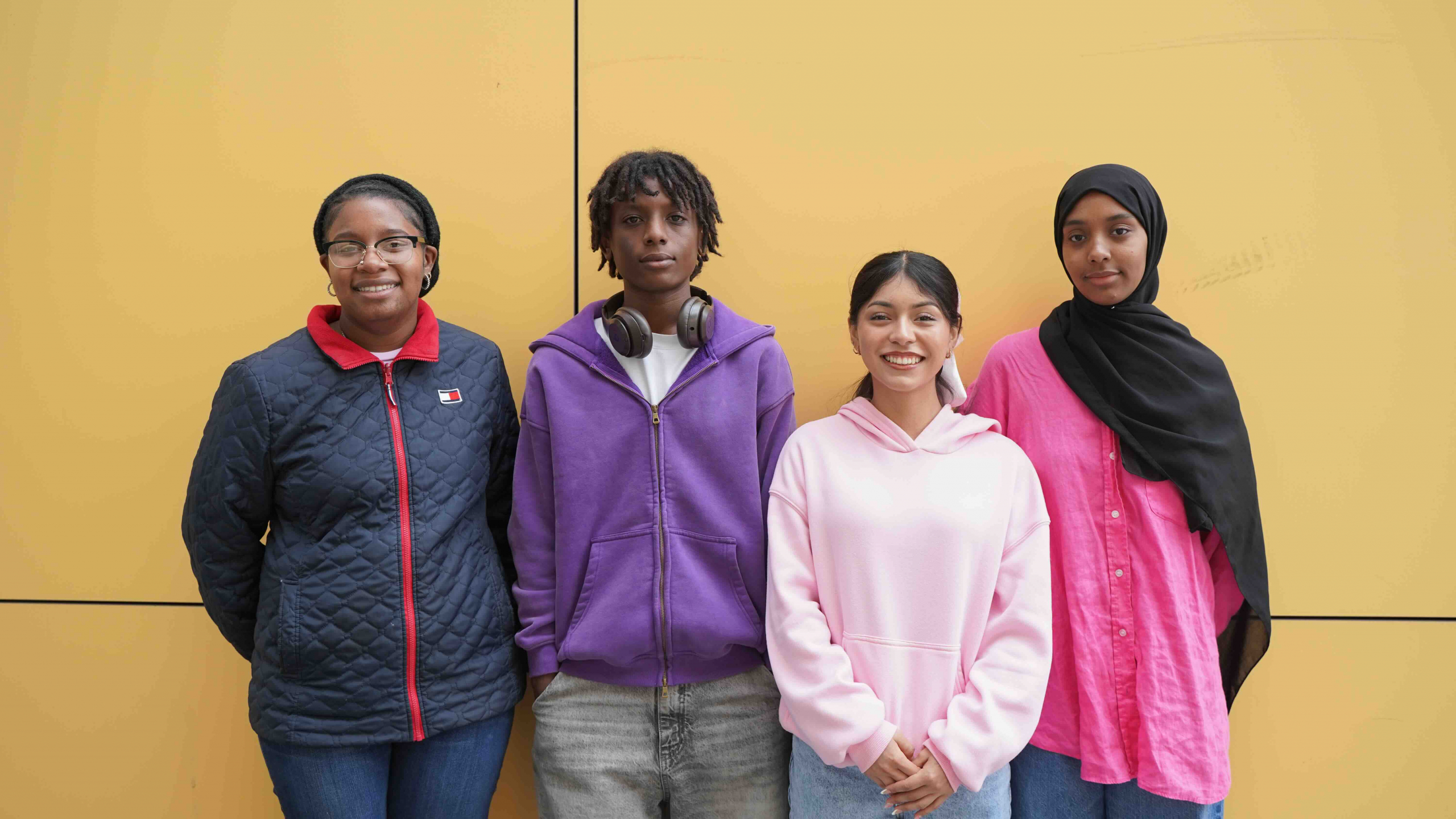 Four high school students from MetWest High School in Oakland, California, standing together and smiling.