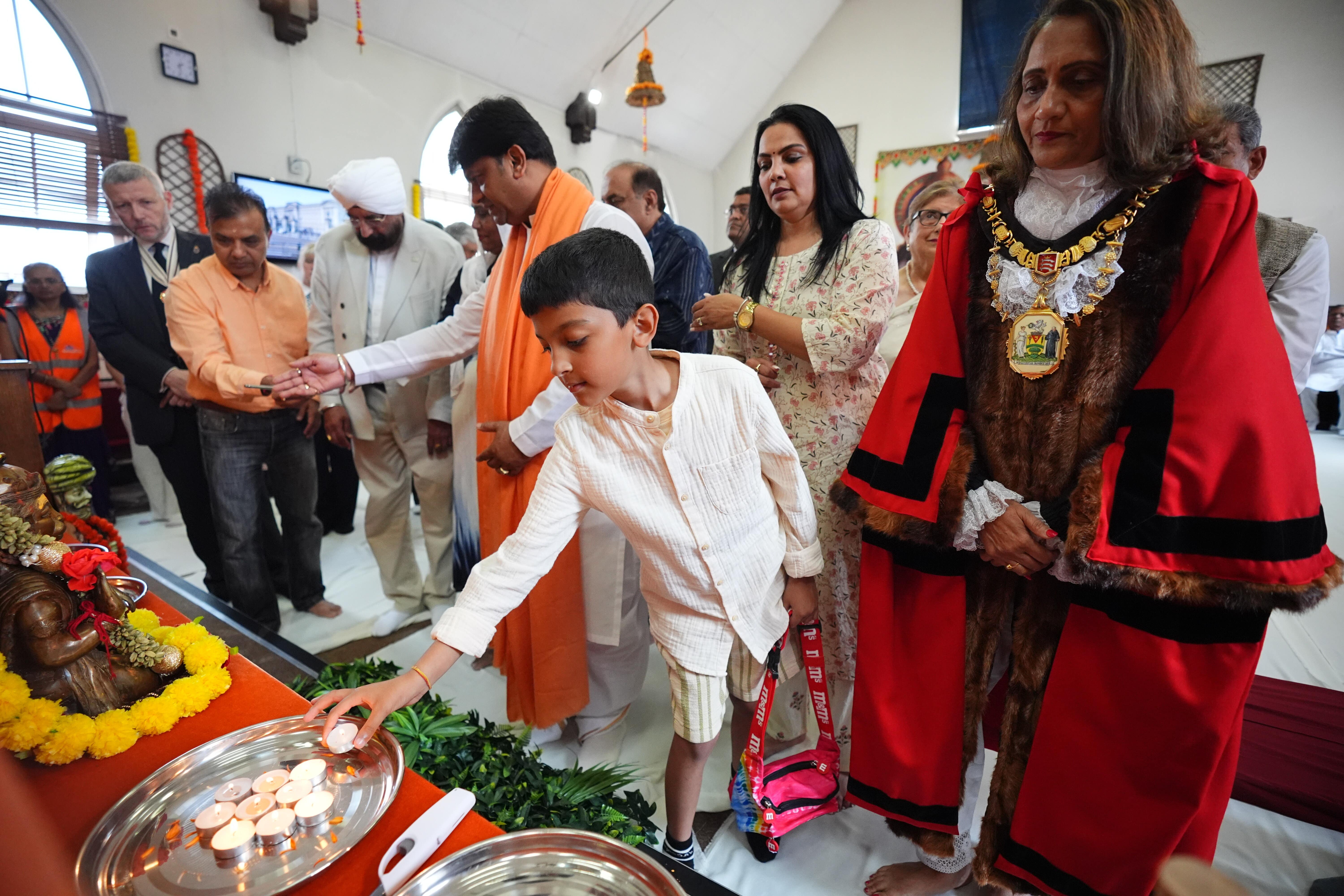 Shri Rajrajeshwar Guruji (centre) and the Mayor of Harrow Councillor Anjana Patel (right) during a multi-faith vigil at the Siddhashram Shakti Centre in Harrow, London, for the victims of the Air India crash (James Manning/PA)