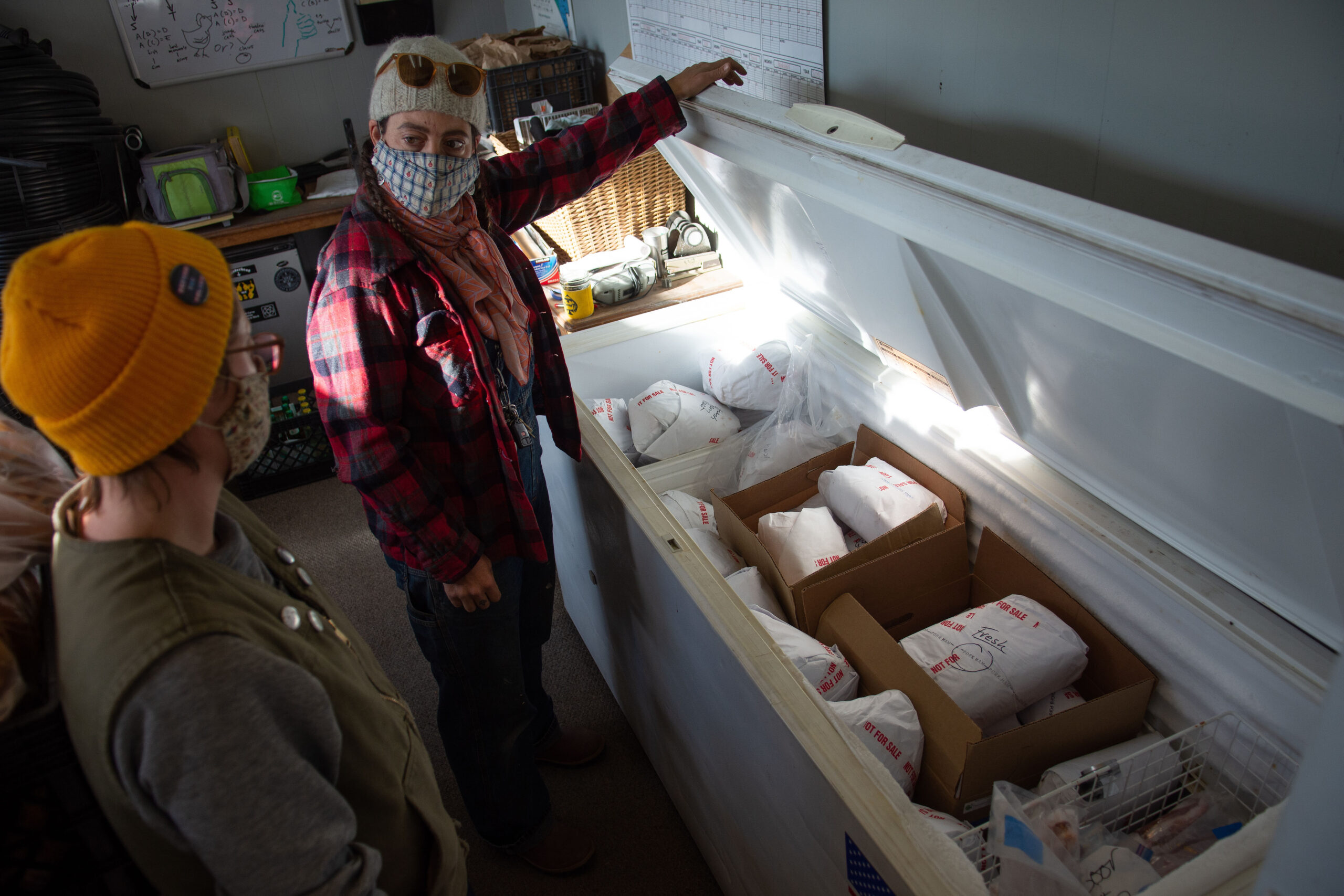 Reno Food Systems' Lyndsey Langsdale, center, and Meagan O'Farrell in front of a freezer full of pork from Fallon's First Fruits Sustainable Farm.