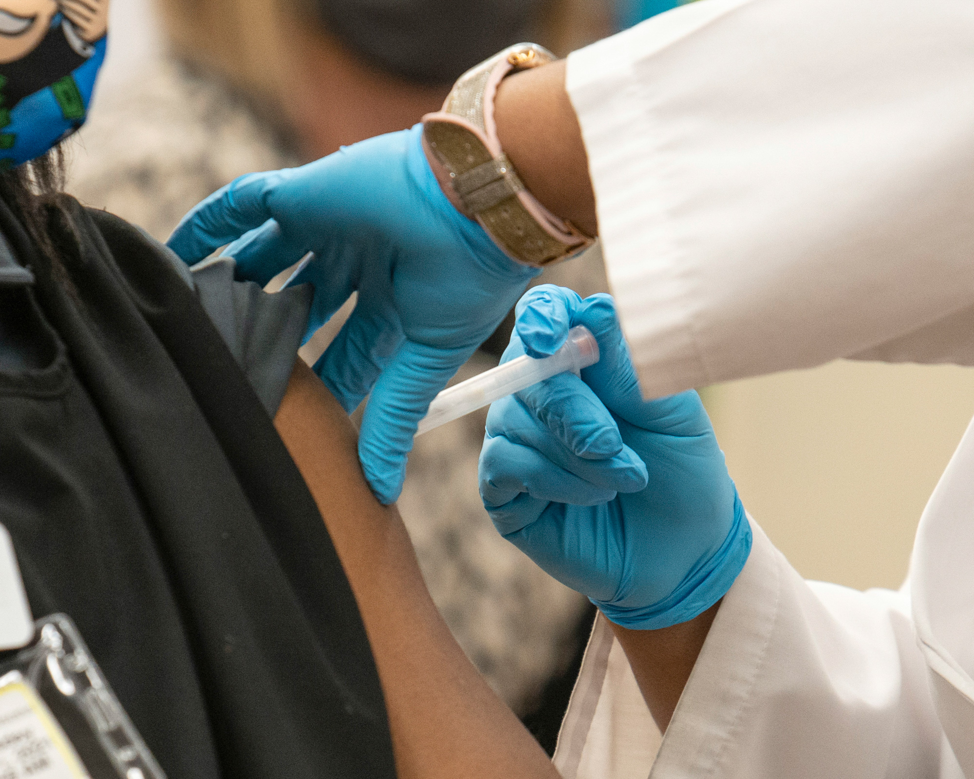 Maylin Illas-Rodriguez, a sanitation clerk, receives a dose of the Janssen COVID-19 vaccine from pharmacist Trashelle Miro at a pharmacy inside an Albertsons grocery store in Las Vegas.