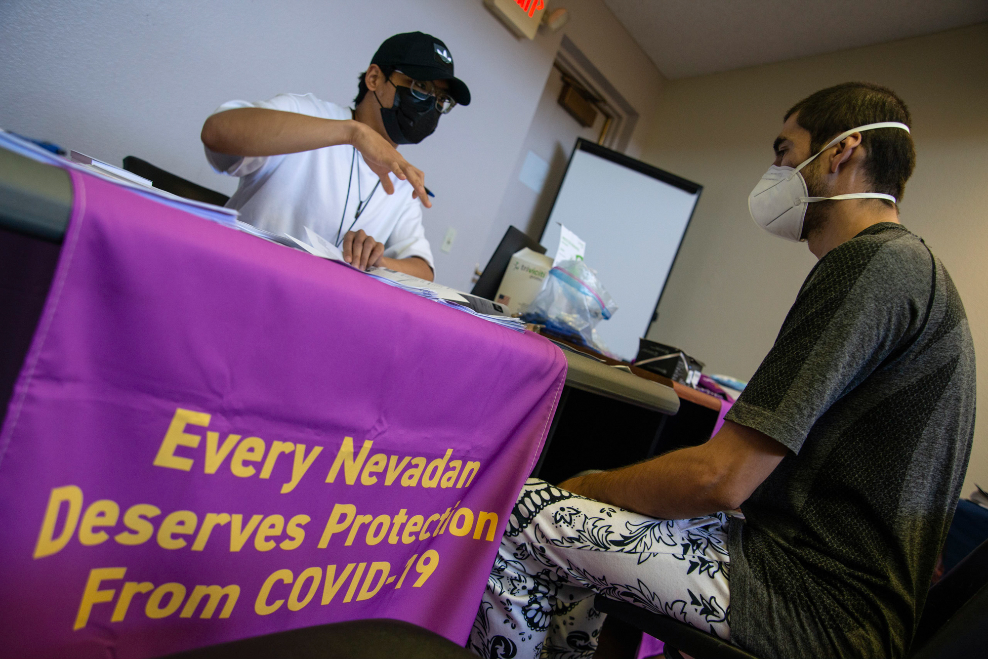 Lauro Solomo, left, helps Carrillo Felipe fill out paperwork during a pop up vaccination clinic at Hullum Homes Apartment Complex in Las Vegas.