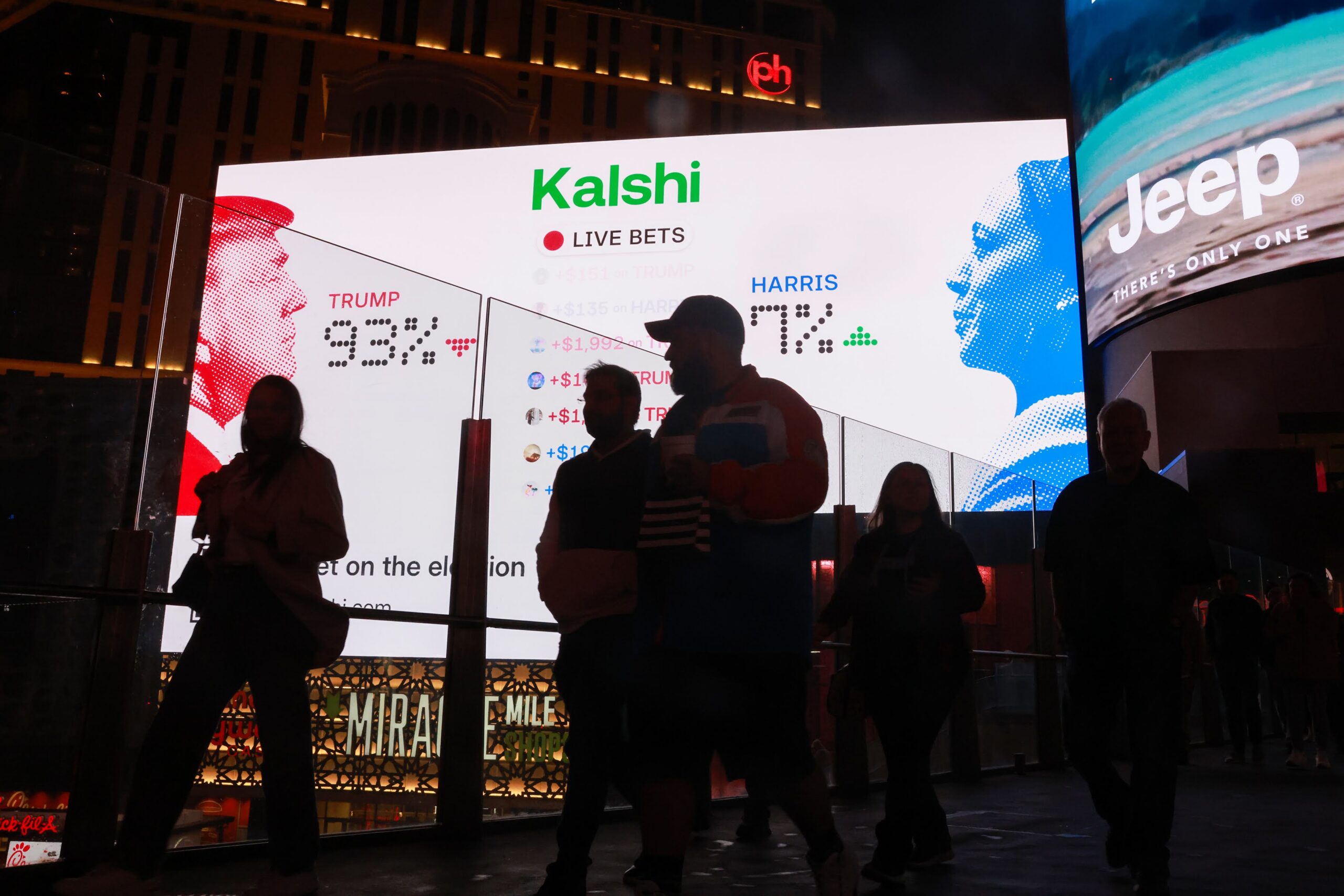 Pedestrians walk near the Kalshi billboard in front of the Miracle Mile Shops at Planet Hollywood.