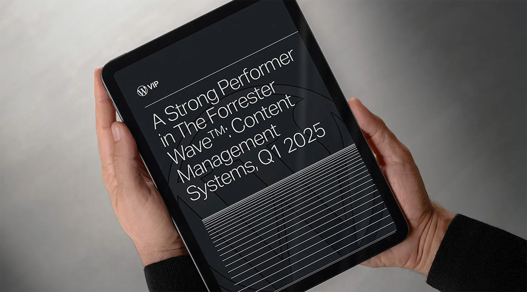 Person holding tablet displaying a Forrester Wave report for WordPress VIP, Q1 2025