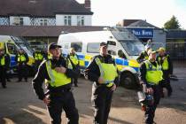 Police gather outside the Bell Hotel in the town of Epping, Essex, England, during a protest ag ...