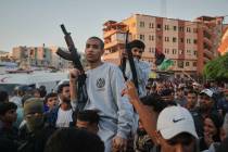 Freed Palestinian prisoners carry rifles as they arrive in the Gaza Strip following their relea ...