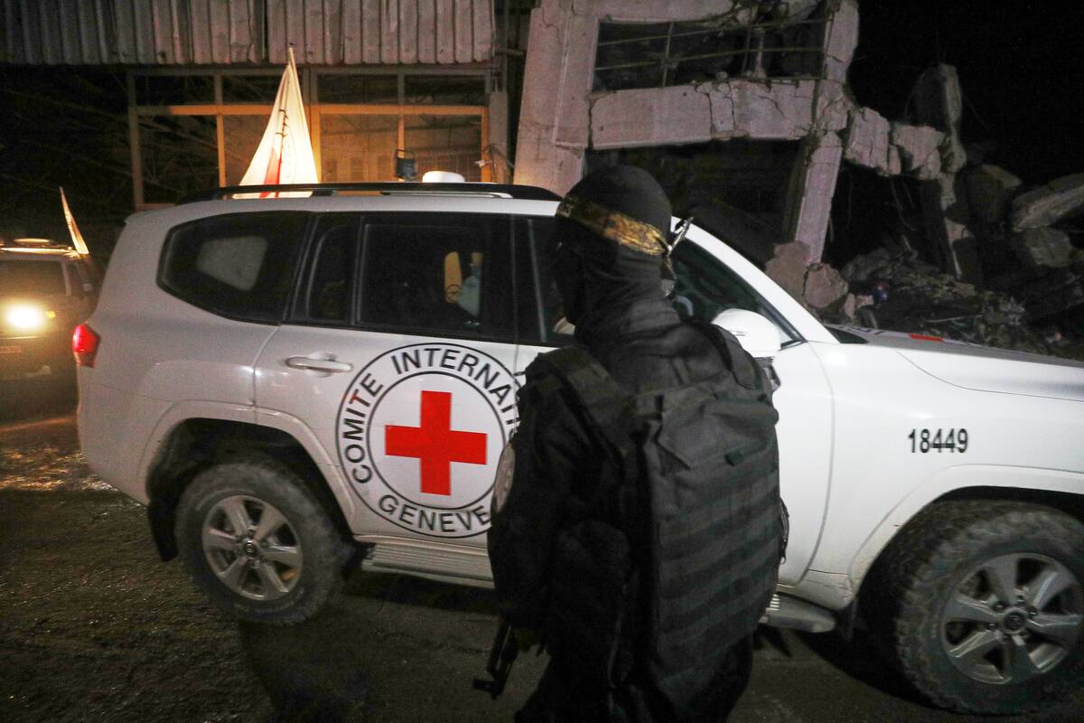 A gunman wearing the uniform of the al-Qassam Brigades, the military wing of Hamas, stands guar ...