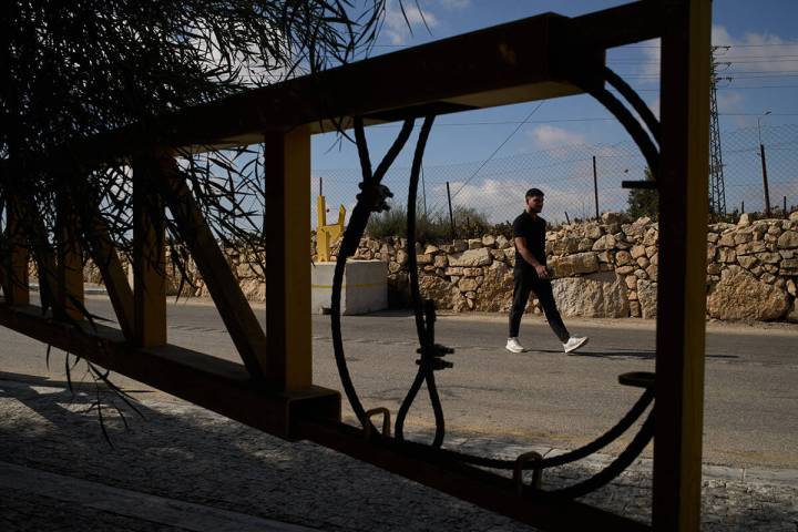 A Palestinian man walks past a gate set up by Israeli authorities at the entrance of the West B ...